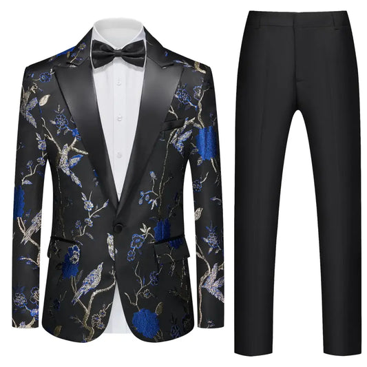 Black tuxedo jacket with intricate blue and gold floral embroidery featuring birds, paired with matching black trousers.