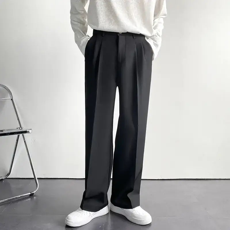 Black pleated trousers with a sleek, modern cut.