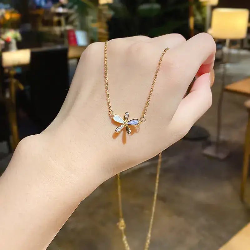 Gold chain necklace featuring a delicate dragonfly pendant with iridescent wings and sparkling gemstone accents.