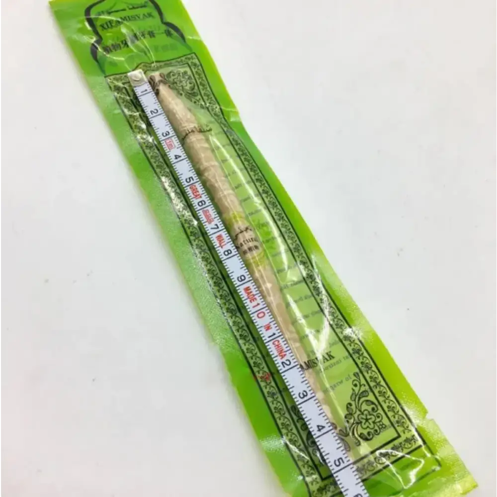 A light beige, textured incense stick packaged in a green foil wrapper with decorative patterns and measurement markings.
