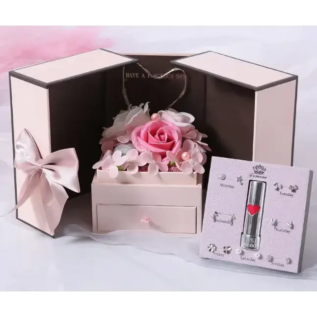 Pink floral arrangement nestled in a matching blush-colored wooden box with a small drawer.