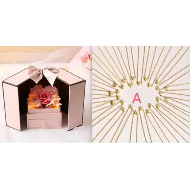 Pink hexagonal box with a beige bow and a drawer, containing dried flowers in shades of pink and orange.