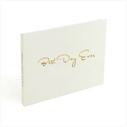 White hardcover photo album with gold foil lettering that reads ’best day ever.’