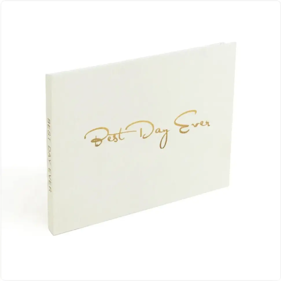 White hardcover photo album with gold foil lettering that reads ’best day ever.’