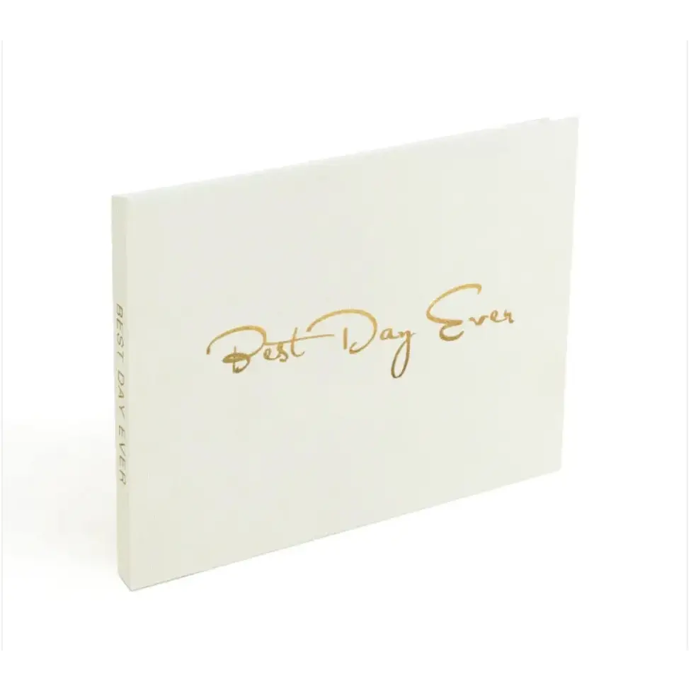 White photo album with gold foil lettering that reads ’best day ever.’
