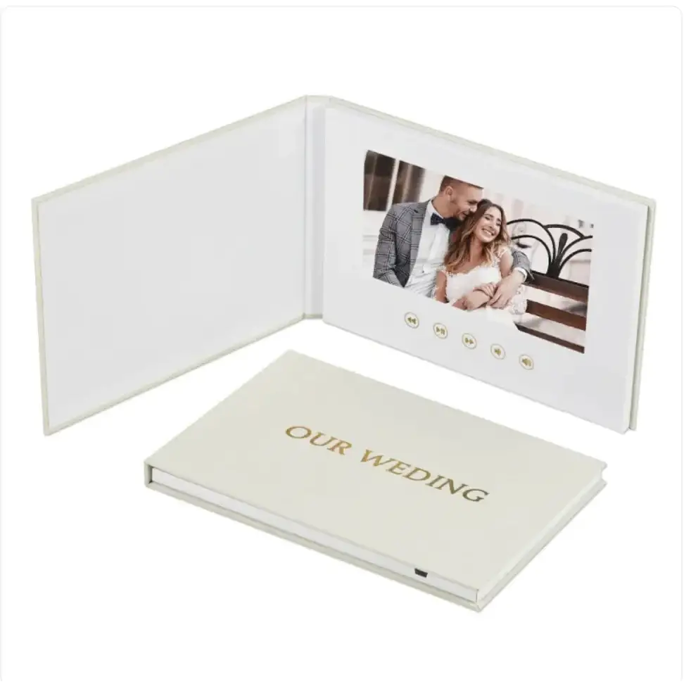 Cream-colored digital photo book with gold foil ’our wedding’ embossing and a built-in screen displaying a couple’s wedding photo.