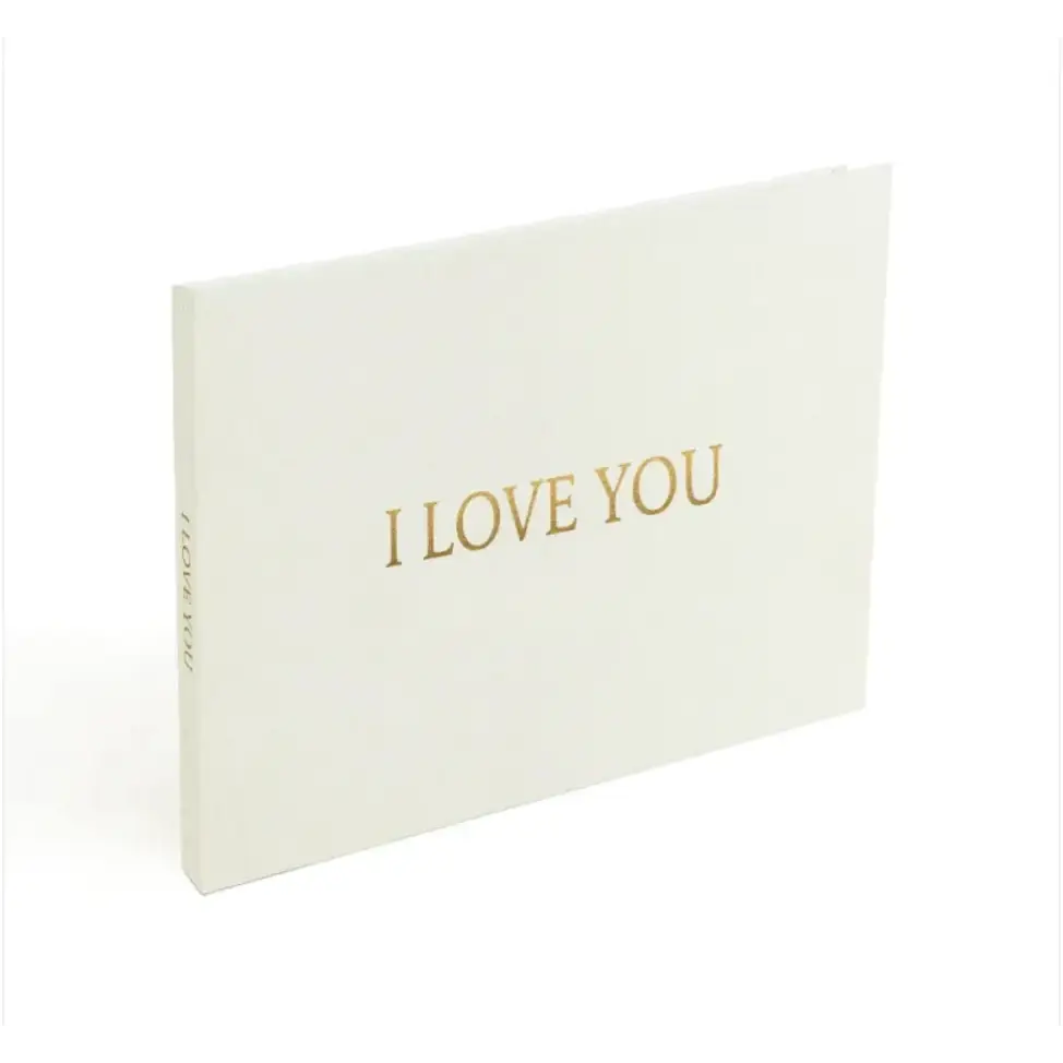 A minimalist white card with elegant gold foil lettering that reads ’i love you.’