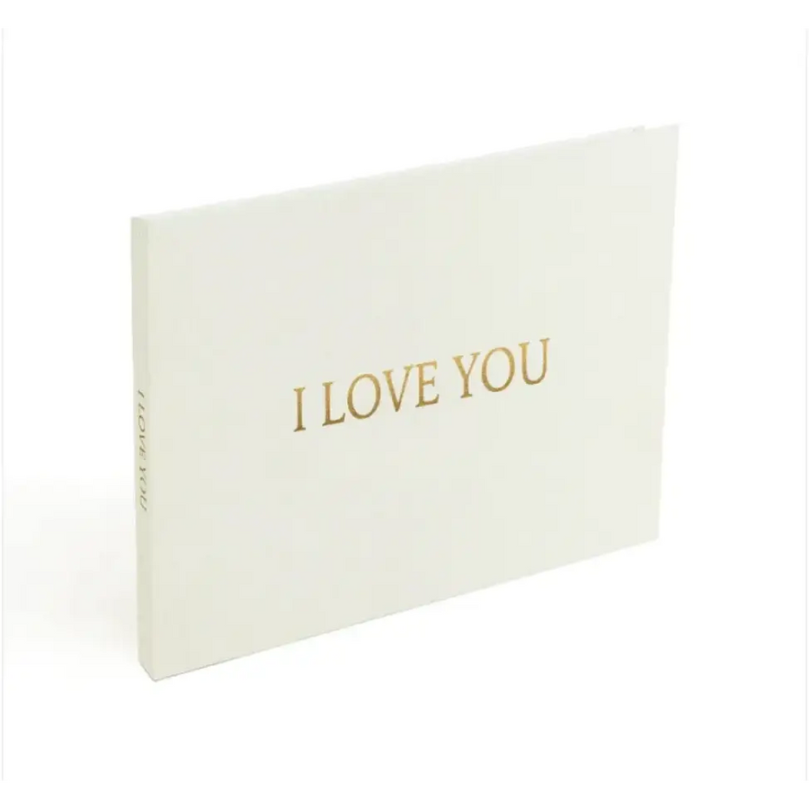 A minimalist white card with elegant gold foil lettering that reads ’i love you.’