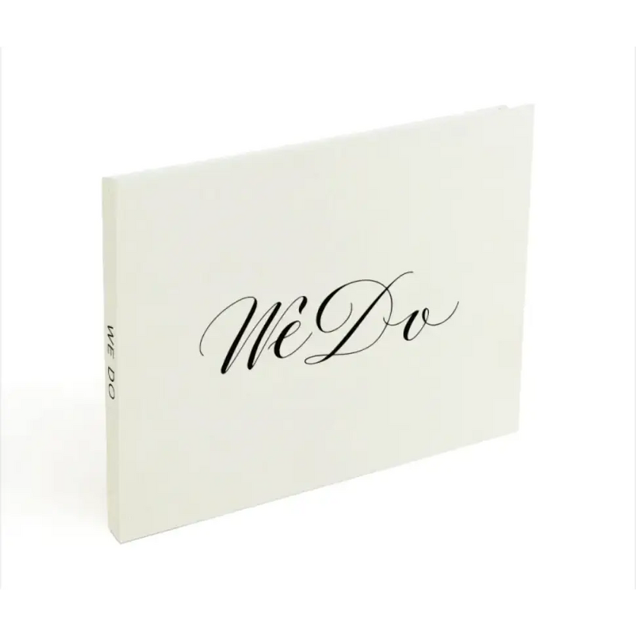 White ’we do’ wedding guest book with elegant black cursive lettering.