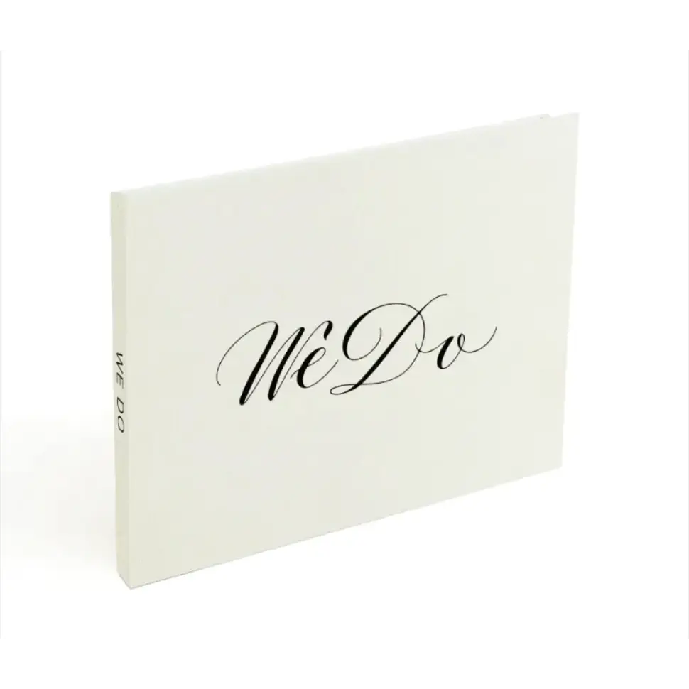 White ’we do’ wedding guest book with elegant black cursive lettering.