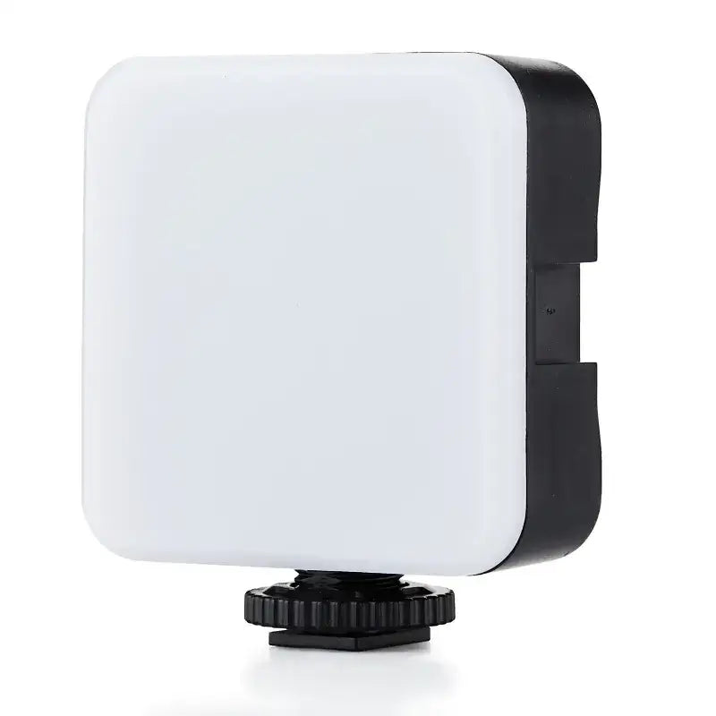 White and black square-shaped led light with a textured base for mounting.