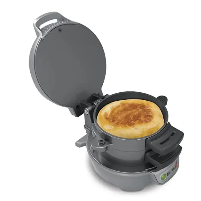 Gray electric pancake maker with a golden-brown pancake cooking inside.