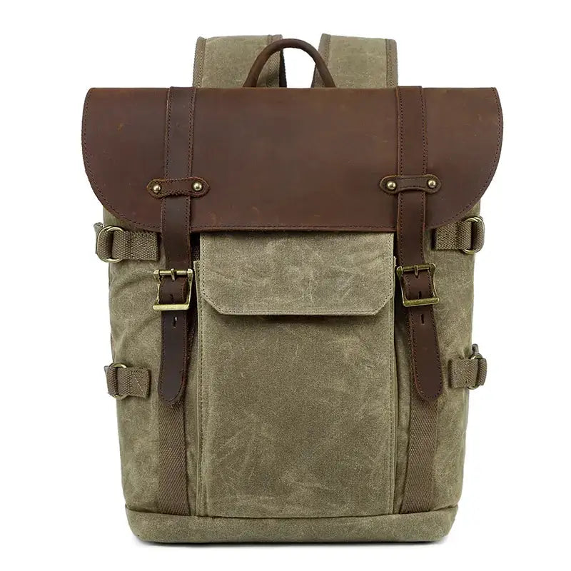 Olive canvas backpack with brown leather accents and brass buckles.