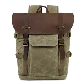 Olive canvas backpack with brown leather accents and brass buckles.