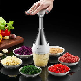 Silver and white electric garlic press with a clear glass container filled with minced garlic.