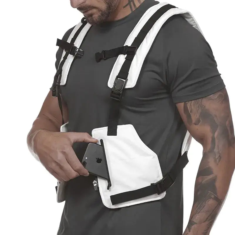 White tactical chest harness with black straps and buckles, featuring a front pocket designed to hold a smartphone.