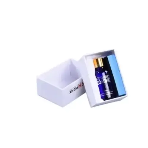 A sleek, dark blue glass bottle with a gold cap and white labeling sits inside an open white gift box.
