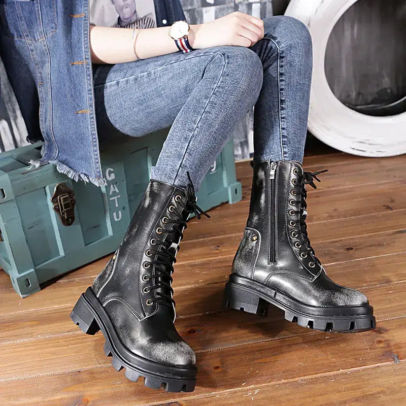 Black distressed leather lace-up combat boots with a chunky rubber sole.