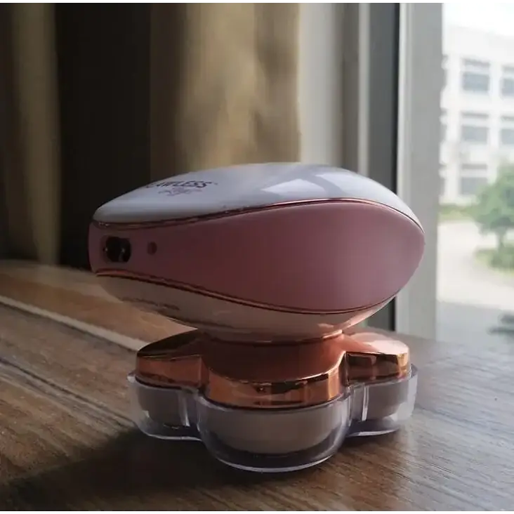 Pink and rose gold electric body hair remover with a sleek, oval-shaped design.