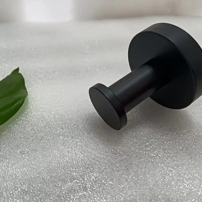 Black matte-finished wall-mounted robe hook with a sleek, cylindrical design.