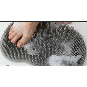 Gray silicone foot scrubber with dense, rounded bristles and a contoured shape for pedicure use.