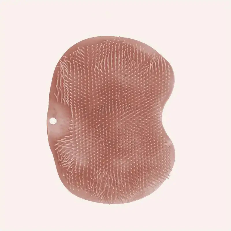 A soft, rose-gold silicone bath brush with a textured surface of fine bristles.