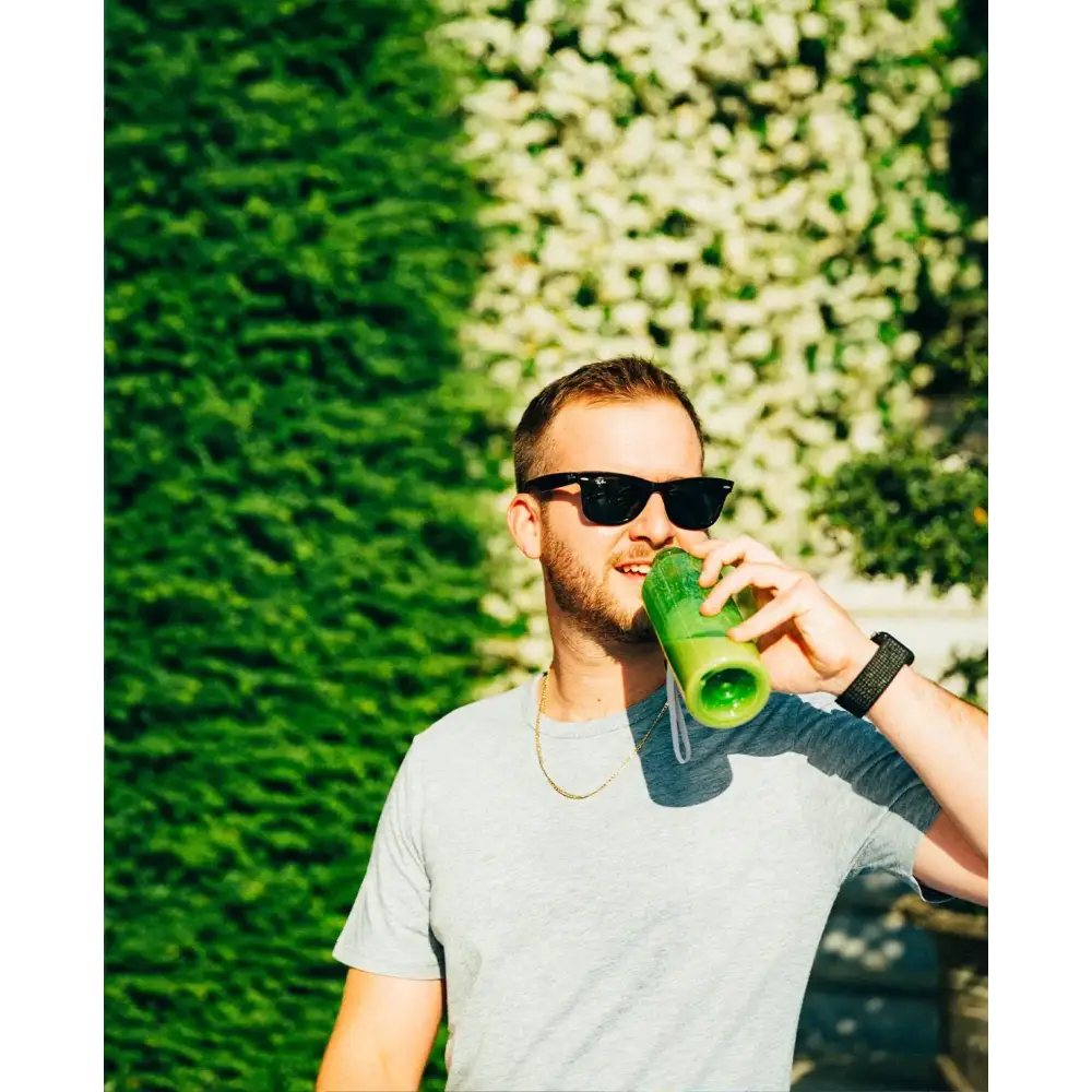Green cylindrical water bottle with a clear straw and white cap