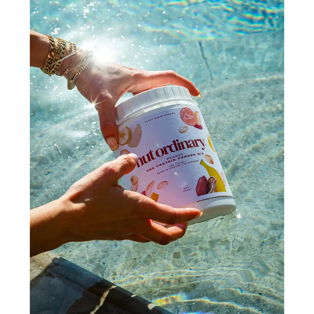 A white cylindrical container of nut ordinary peanut pea protein powder mix, featuring a colorful label with illustrations of peanuts and peas.