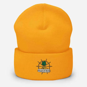 Bright orange knit beanie featuring an embroidered logo of a pineapple on a ship’s wheel with the text ’tropical seas’ beneath it.