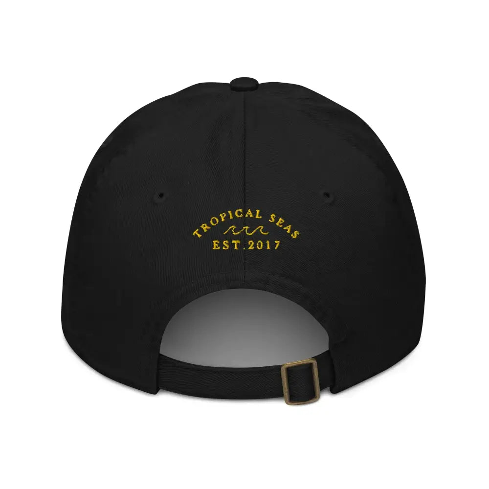 Black baseball cap with gold embroidered ’tropical seas’ and wave design above ’est.