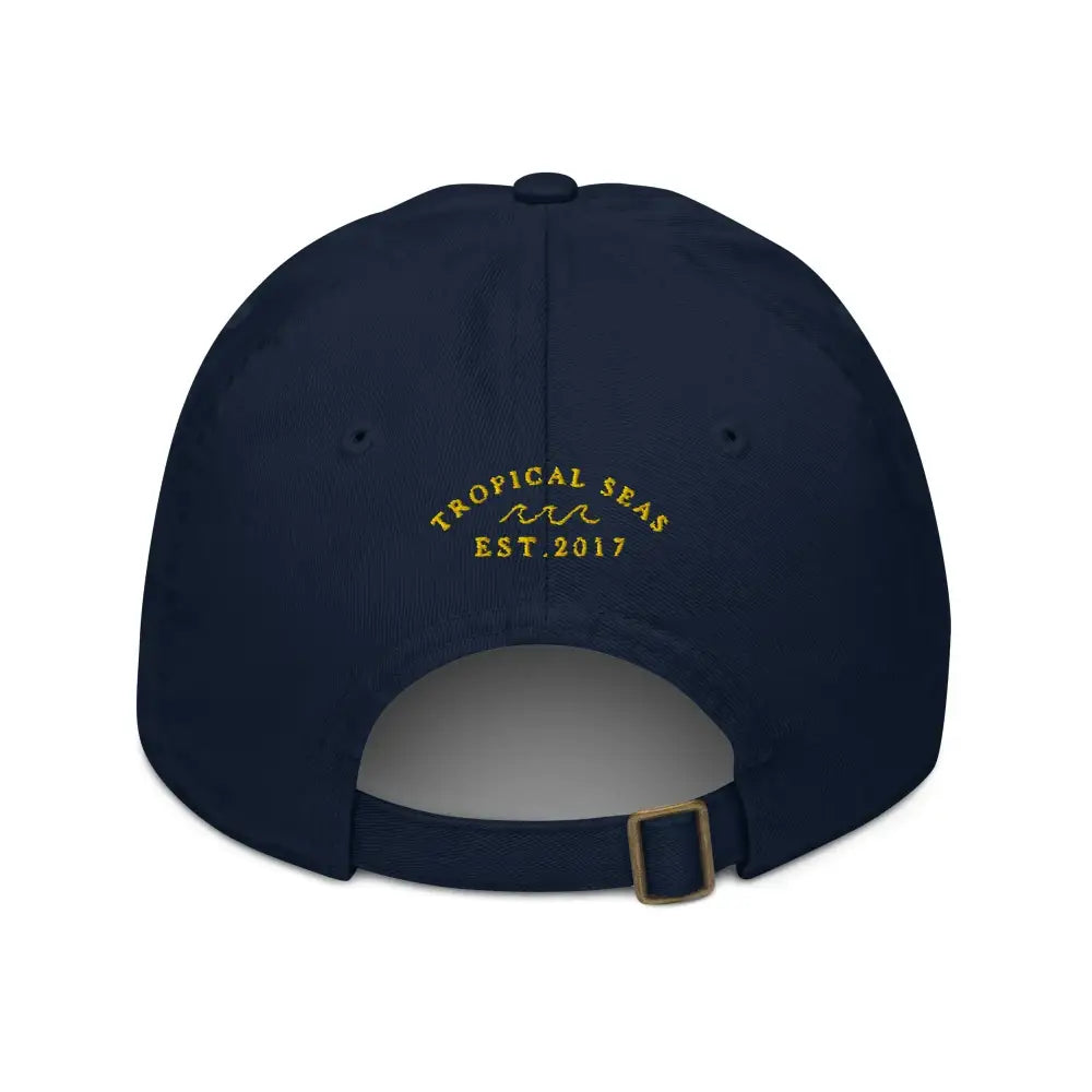 Navy blue baseball cap with gold embroidered ’tropical seas’ and wave logo above ’est.
