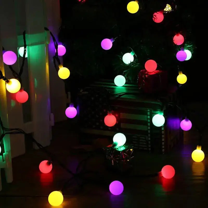 A string of colorful, round led christmas lights with a soft glow in various hues including red, yellow, purple, green and white.