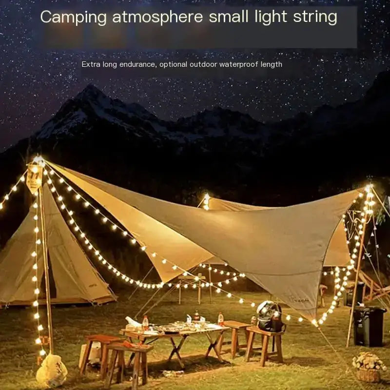 Warm white led string lights strung across a beige camping tarp, creating a cozy glow against the starry night sky.