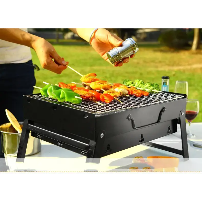 Black portable folding charcoal grill with metal grate and handle