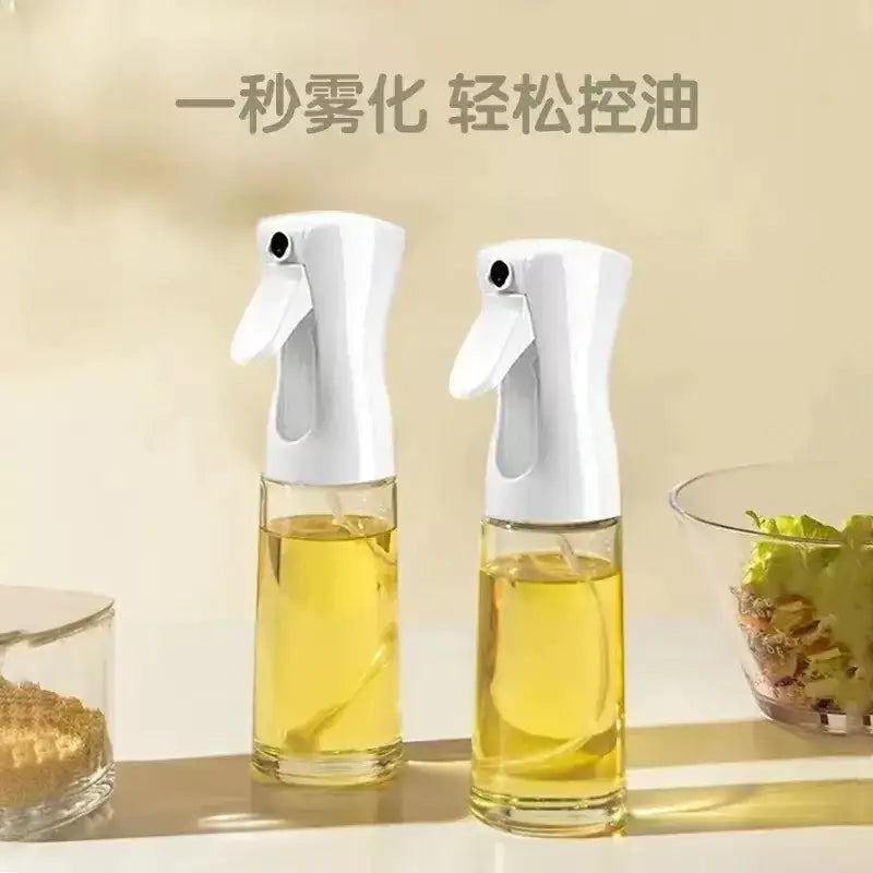 Two white spray bottles with clear glass bodies filled with golden-yellow oil, designed for easy misting and controlled drizzling.