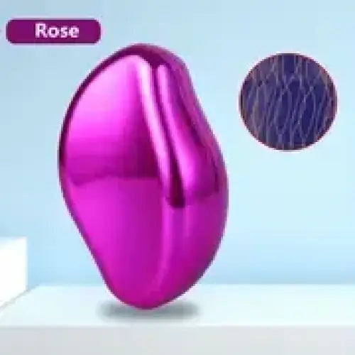 A glossy rose-colored, pearlescent, organic-shaped beauty tool with a smooth, curved surface.