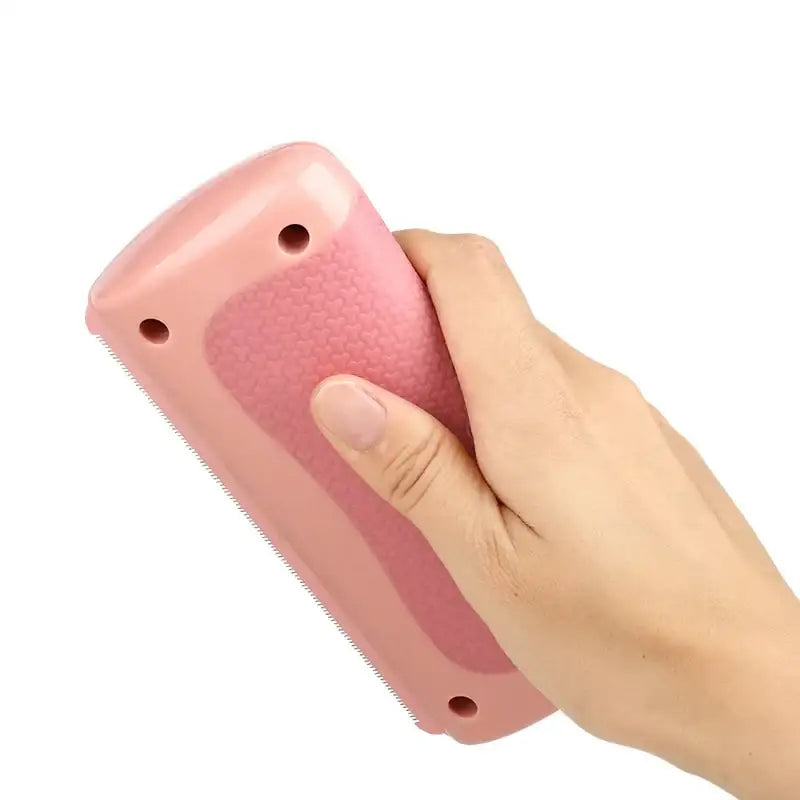 Pink plastic pet grooming brush with a textured grip and rounded edges.