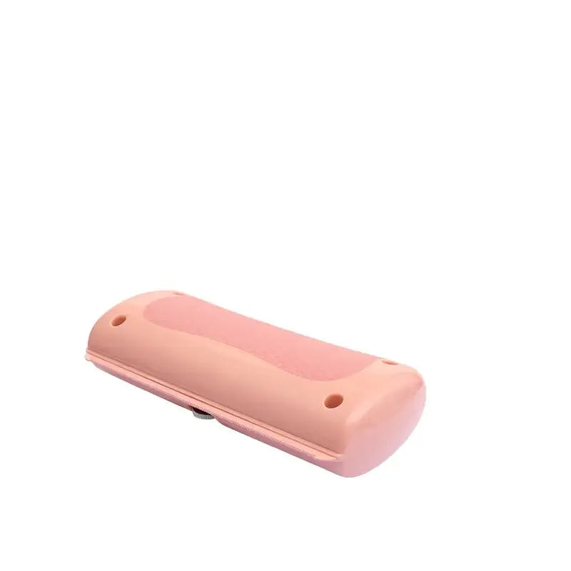 Pink plastic pet grooming tool with a smooth, rounded design and textured grip area.