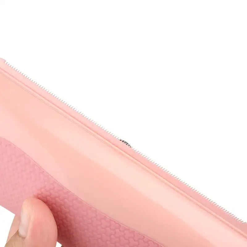 Pink silicone pouch with a zipper closure and textured bottom surface.