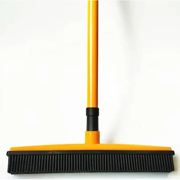 Yellow and black floor sweeper with a long handle and dense bristles.
