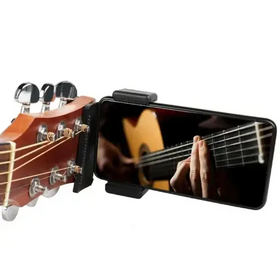 Black smartphone mounted on a guitar headstock clamp, displaying an image of hands playing a classical guitar.