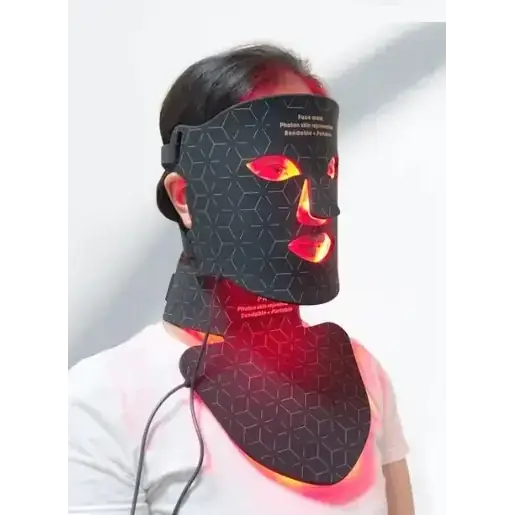 Black hexagonal-patterned facial mask with glowing red led lights illuminating the eyes, nose, and lips.