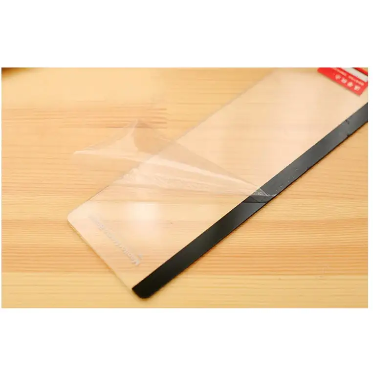 Clear protective screen film with a black border, partially peeled back to reveal its adhesive side.