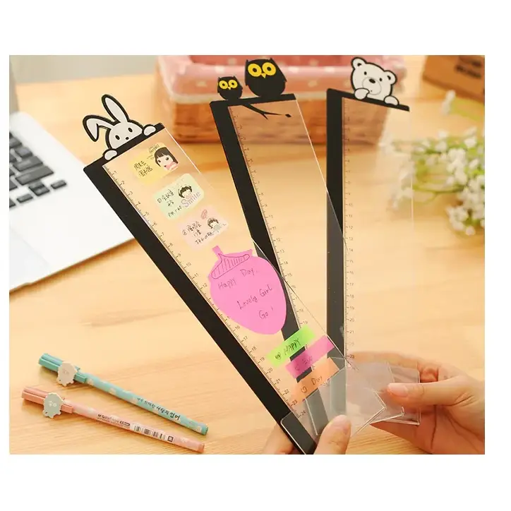 Clear plastic ruler with black cartoon animal toppers and sticky notes attached.