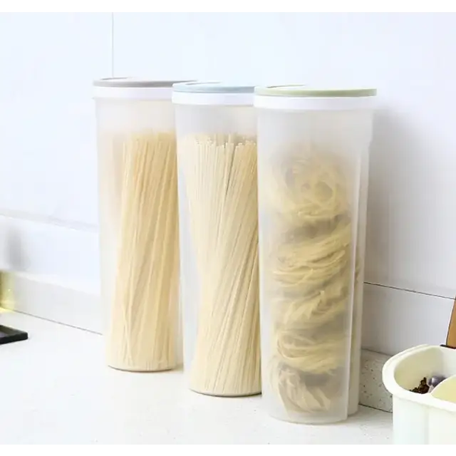 Three translucent plastic storage containers with white lids, each holding different types of dried pasta.