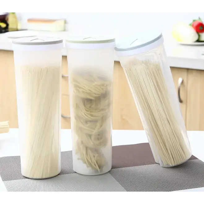 Three transparent cylindrical storage containers with white lids, each holding different types of dried pasta.