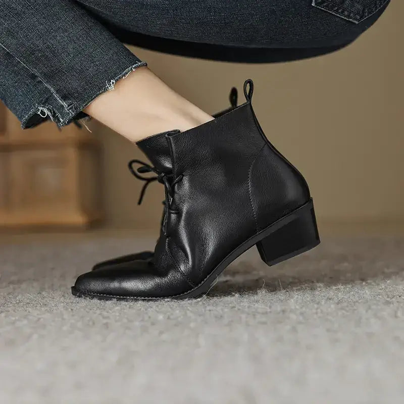 Black leather ankle boot with a low block heel and lace-up front.