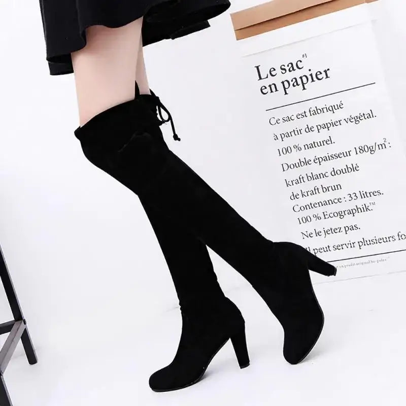 Black over-the-knee boots with a suede-like texture and a modest block heel.