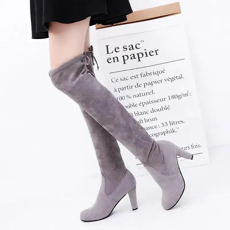 Gray suede over-the-knee boots with a high heel and side tie.