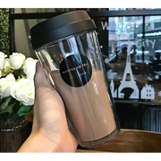 Clear double-walled travel tumbler with a black lid and a circular label that reads ’coffee or tea 20oz’.